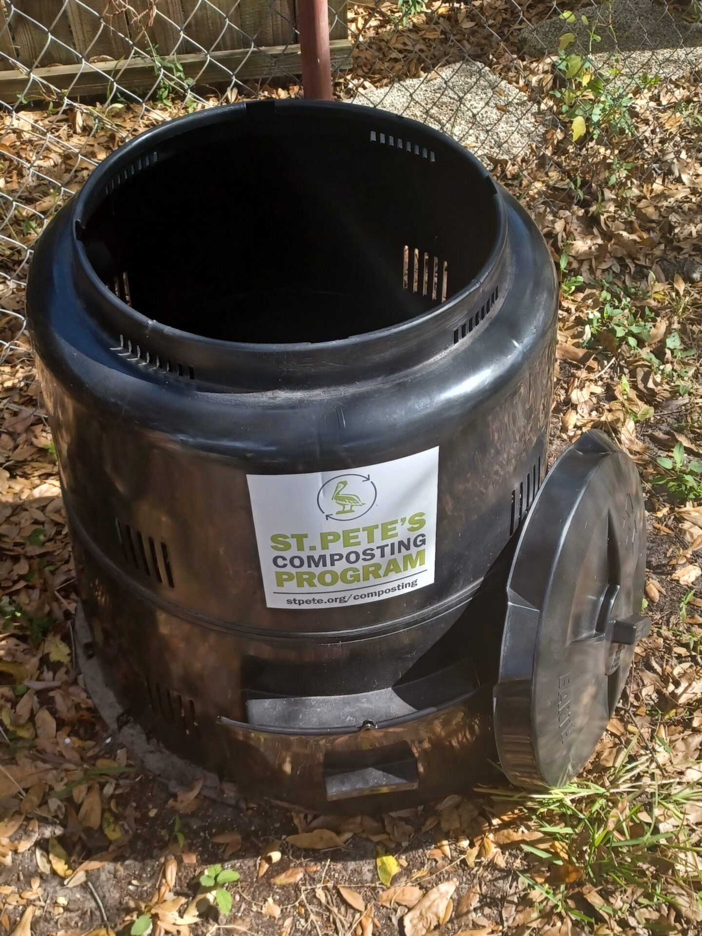 Black compost bin. Label reads St. Pete's Composting Program.